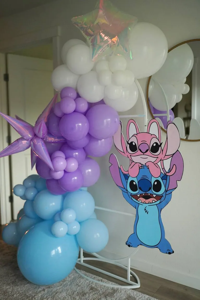 Purple and blue balloon arch with a character cutout