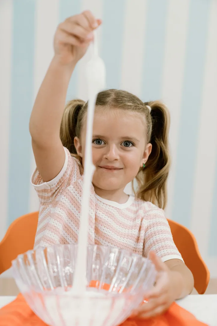 Girl playing with slime at a party table