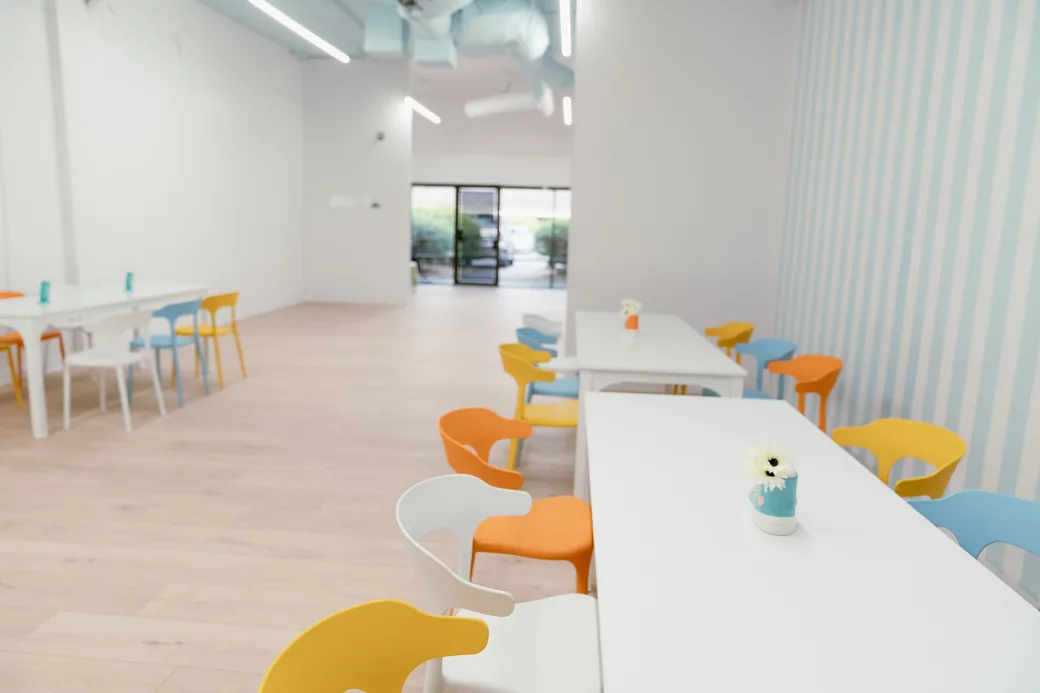 Bright party room with tables and colourful chairs